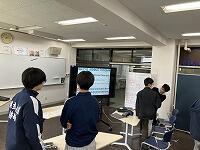 【写真：ペアワークで元気よく発話する生徒たちの様子】