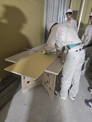 職人の方々の指導を受けながら、軽天工事や石こうボード張りの作業を体験する生徒たち